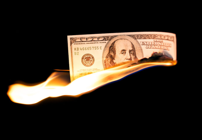 a hundred dollars burn in a fire on a black background
